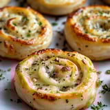 A close up of a pastry with cheese and herbs.