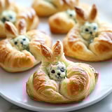 A plate of pastries with a bun shaped like a rabbit.